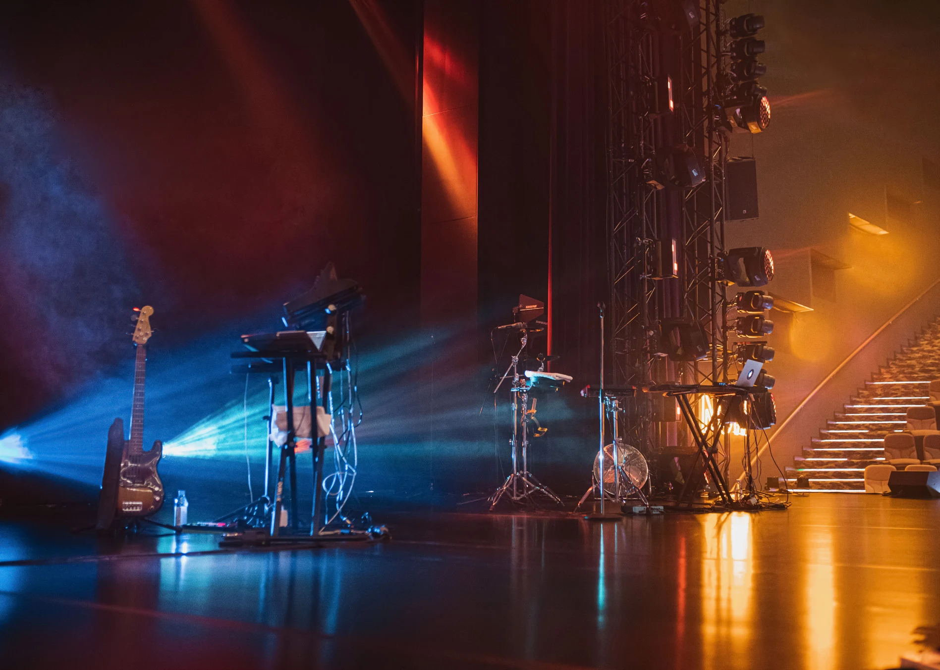 Blue and amber beams illuminating a dark performance stage