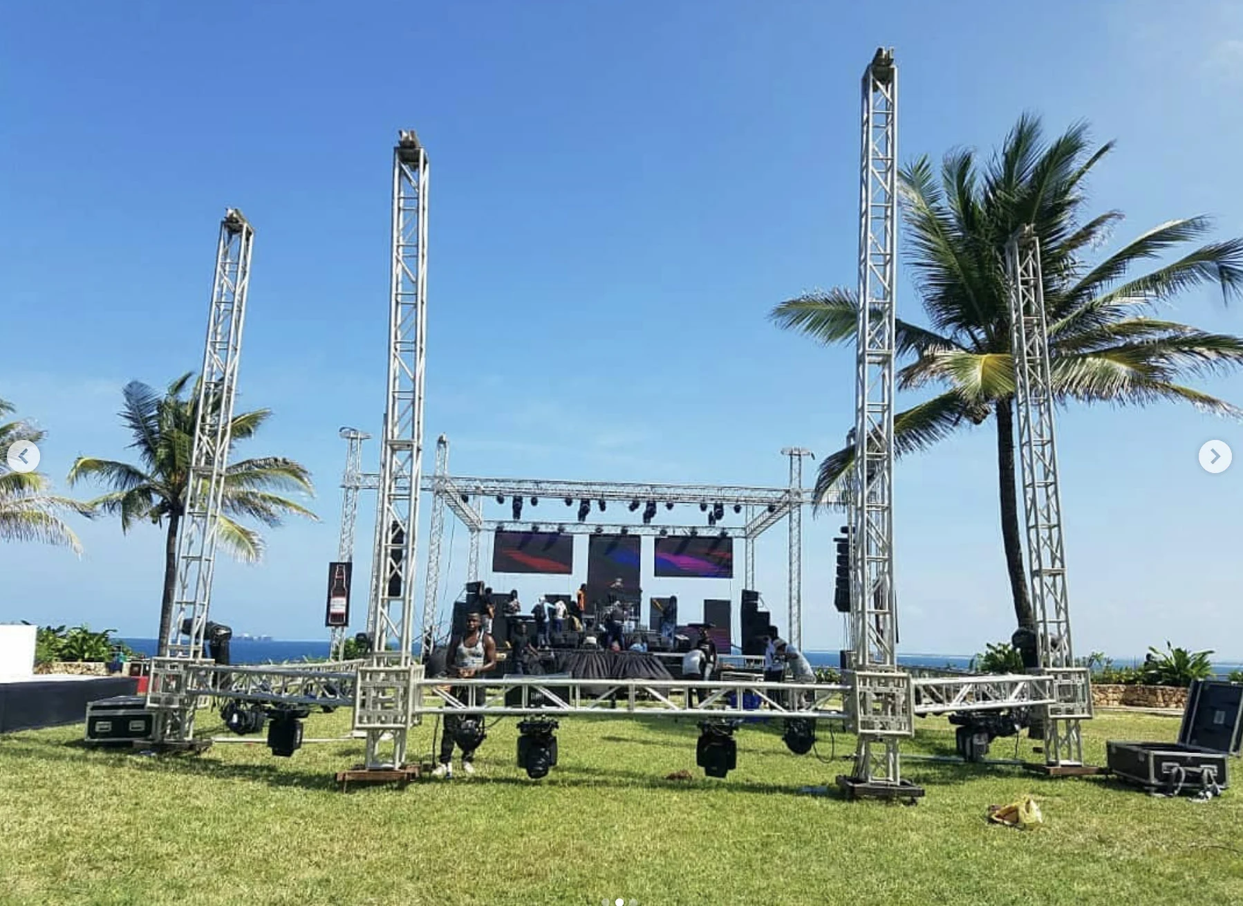 Outdoor production stage and truss towers among palm trees